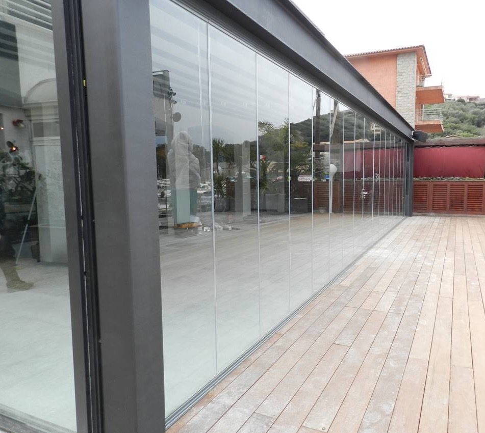 Cortina de cristal instalada en terraza moderna con vista al jardín