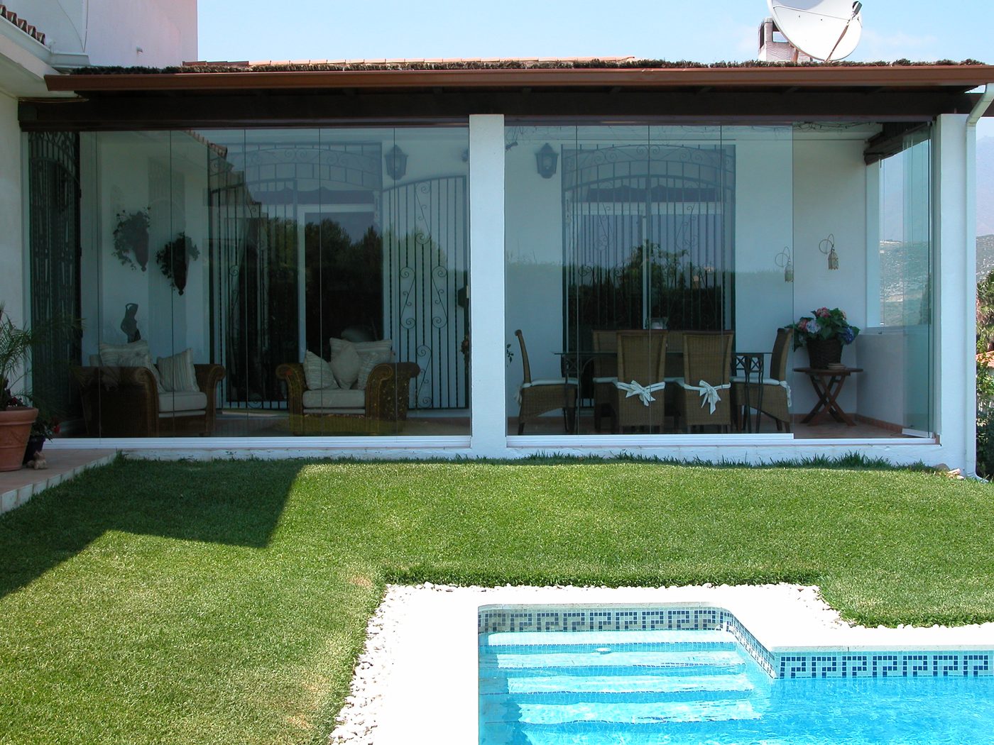 Sistema de cortinas de cristal instalado en contexto residencial